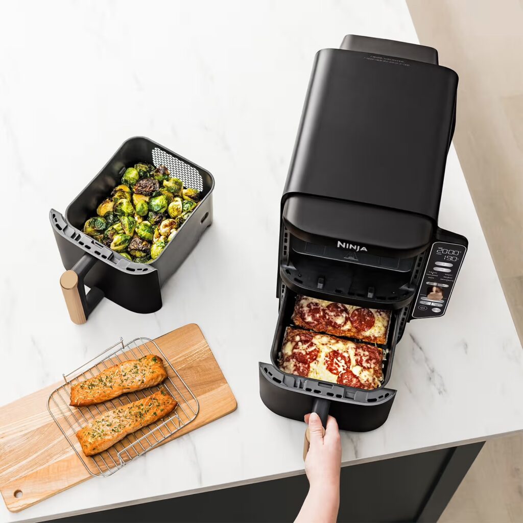 Ninja-R-SL400UKCP-InUse-Kitchen-OnCounter-RemovingFood-Pizza-Woman-RGB